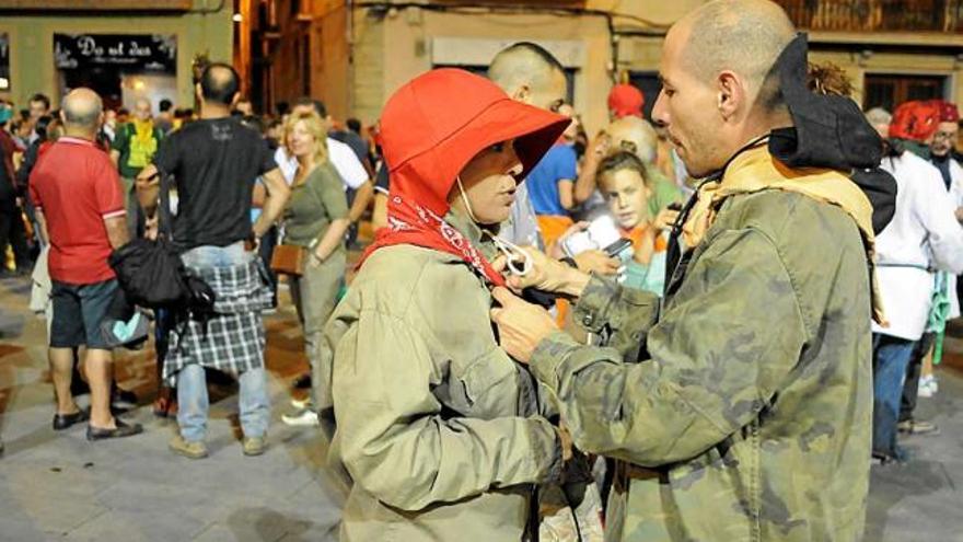 Dos participants en el correfoc preparant-se abans de començar