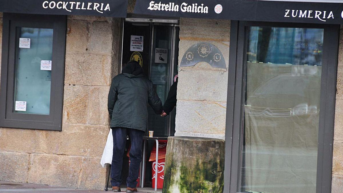 Un cliente adquiere un café para llevar en una cafetería de Cangas. |   // GONZALO NÚÑEZ