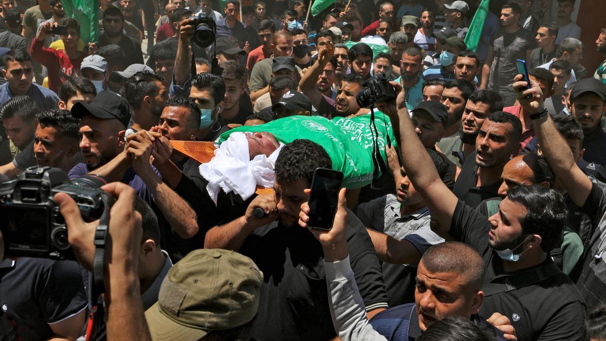 Manifestantes ondean banderas verdes mientras lloran la meurte de varios palestinos por bombardeos israelís en Gaza.