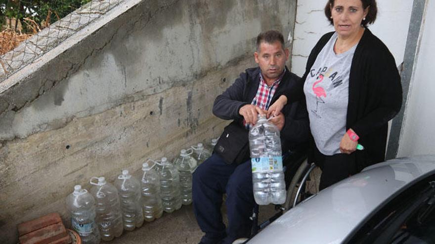 Pepe Fernández y Adela Anaya, dos vecinos de Los Gámez, con las garrafas de agua que tienen que usar a diario.