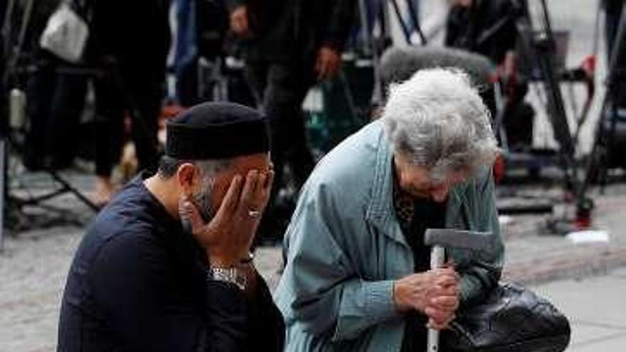 Un musulmán y una mujer judía lloran en una ofrenda floral. // Reuters