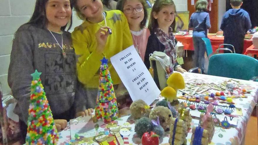 Lucía Carrio, Alicia Alonso, Gelinos Ramírez, Nora Alonso y Sara Peña, ayer, en su puesto de manualidades del mercadillo solidario.