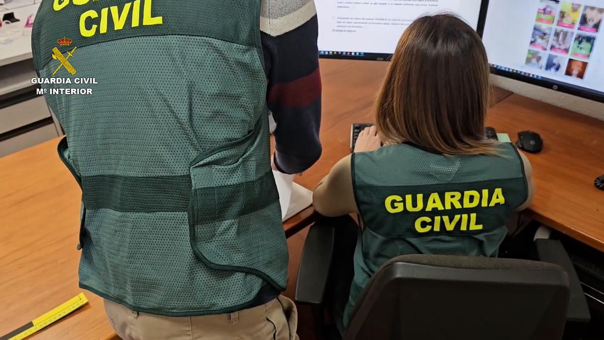 Dos agentes revisan el material que ha servido de base para detener por delito de odio al divulgador.