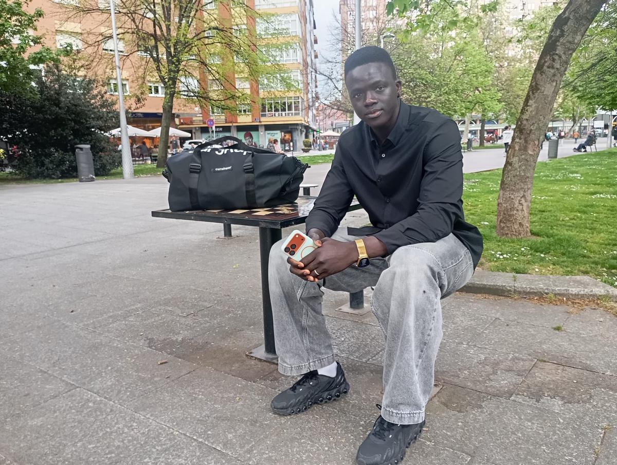 Mansour Gueye , sentado en el parque de Las Meanas de Avilés.