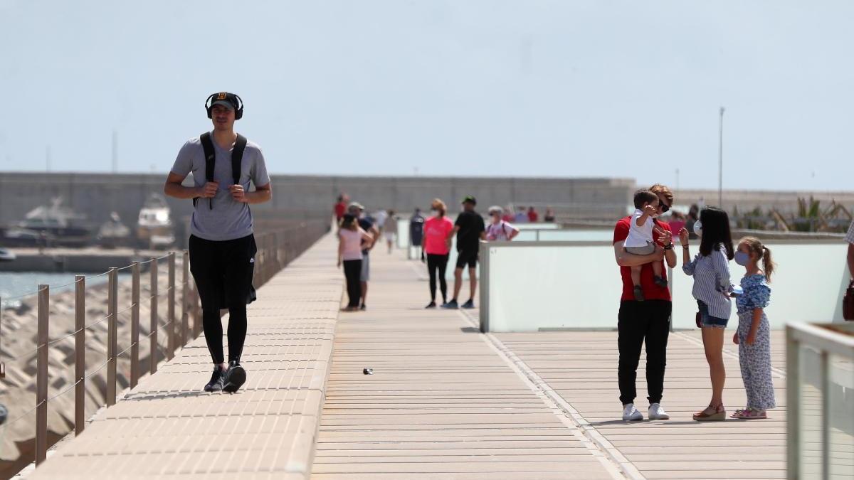 Vecinos de València pasean por el espigón norte del puerto.