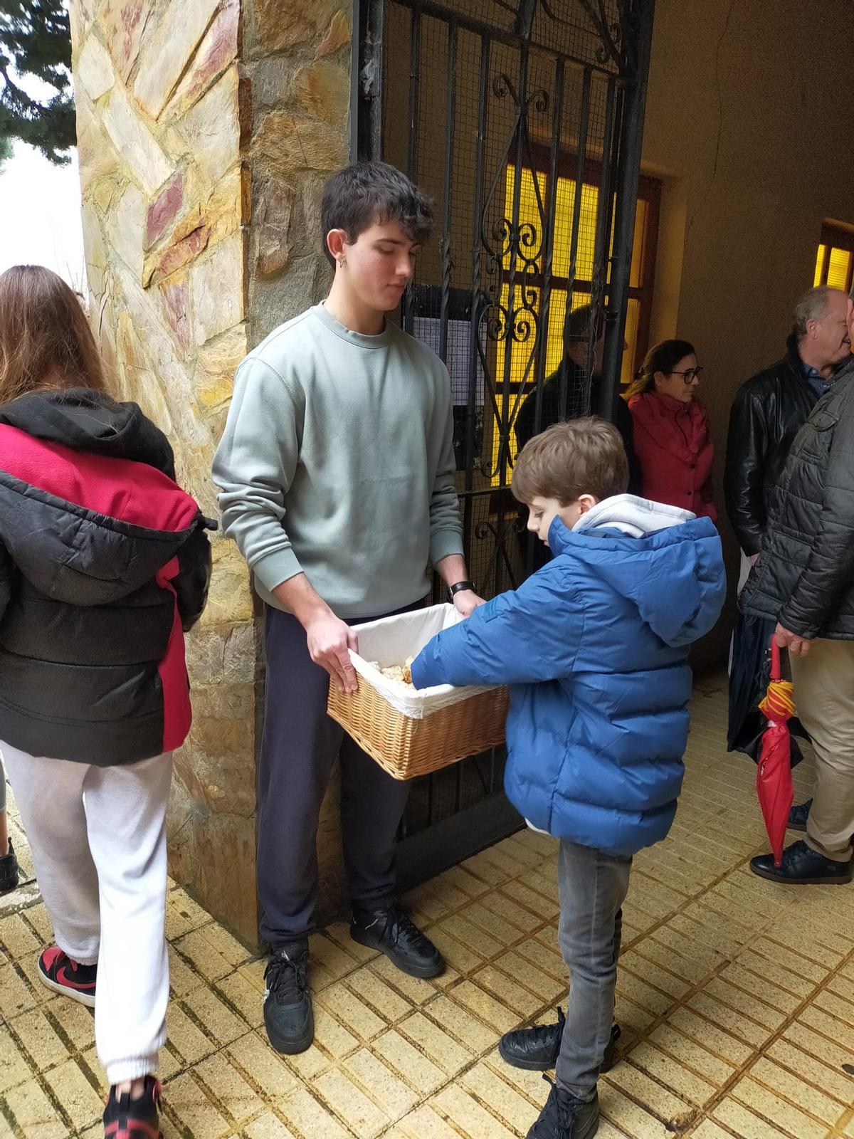 El Entrante de mayor edad ofrece pan a la salida de la iglesia.