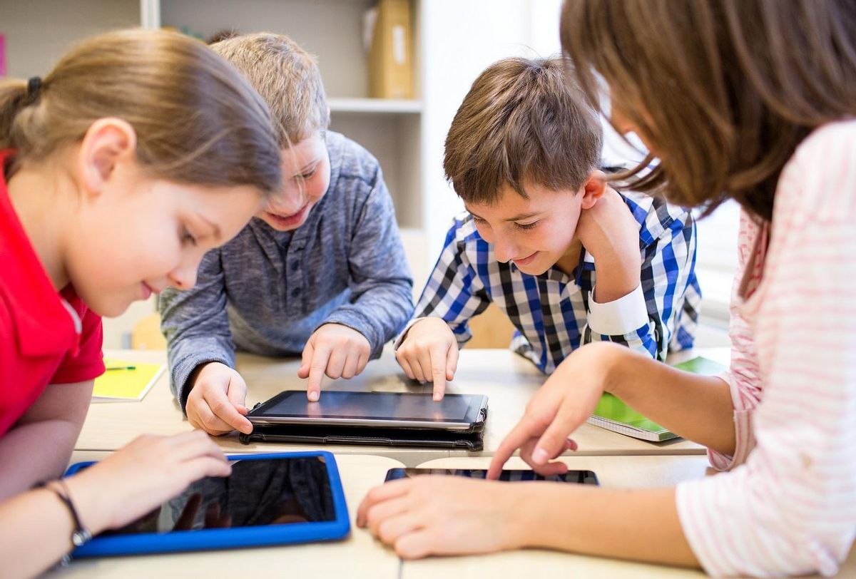 Group of children using tablets at school