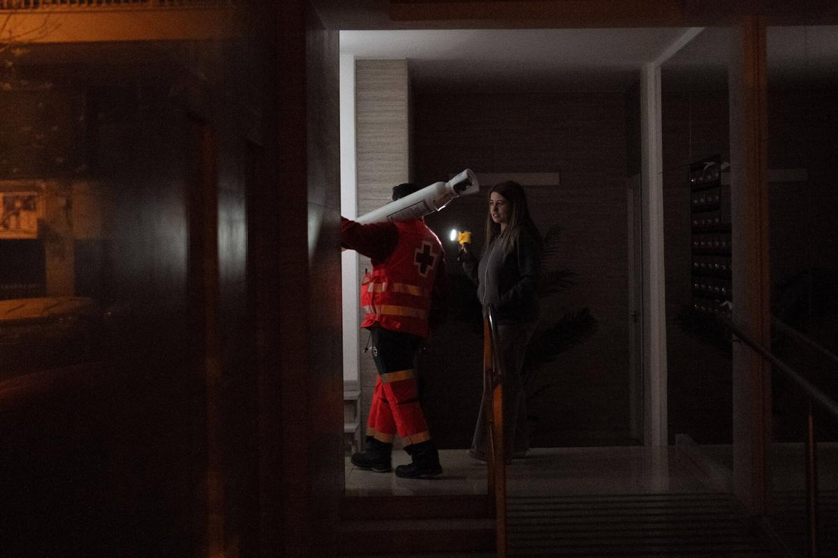 BARCELONA 28/04/2025 Sociedad. Cruz Roja lleva una bombona de oxigeno a un paciente con problemas respiratorios, ya que sin luz en el edificio necesita asistencia externa. Media noche en la ciudad el día que hubo el apagon electrico en españa. FOTO de ZOWY VOETEN