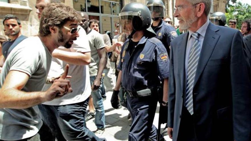 El ex jefe del Consell Joan Lerma, escoltado por la Policía a la salida de las Cortes.