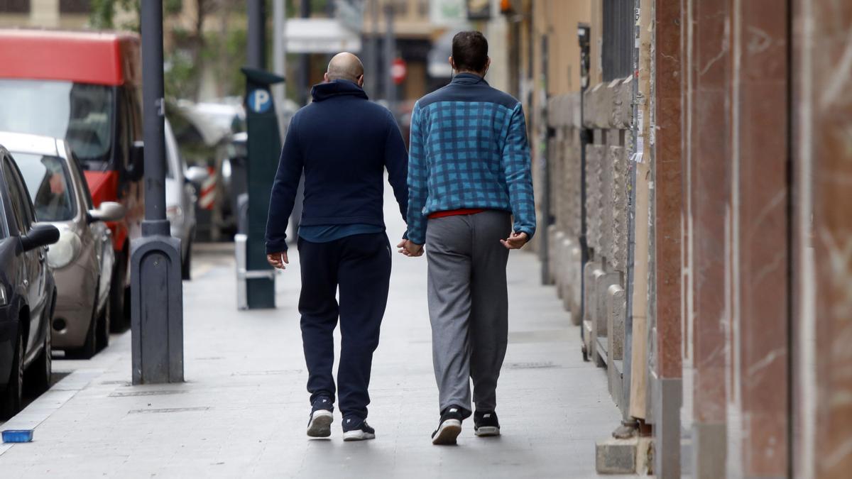 Imagen de archivo de una persona con diversidad funcional por la calle con un familiar