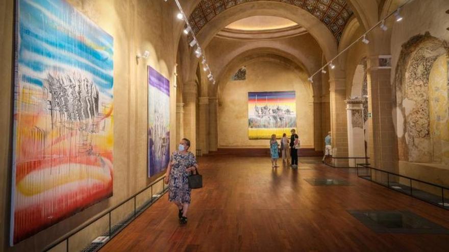 Una mujer observa uno de los cuadros que componen la exposición.