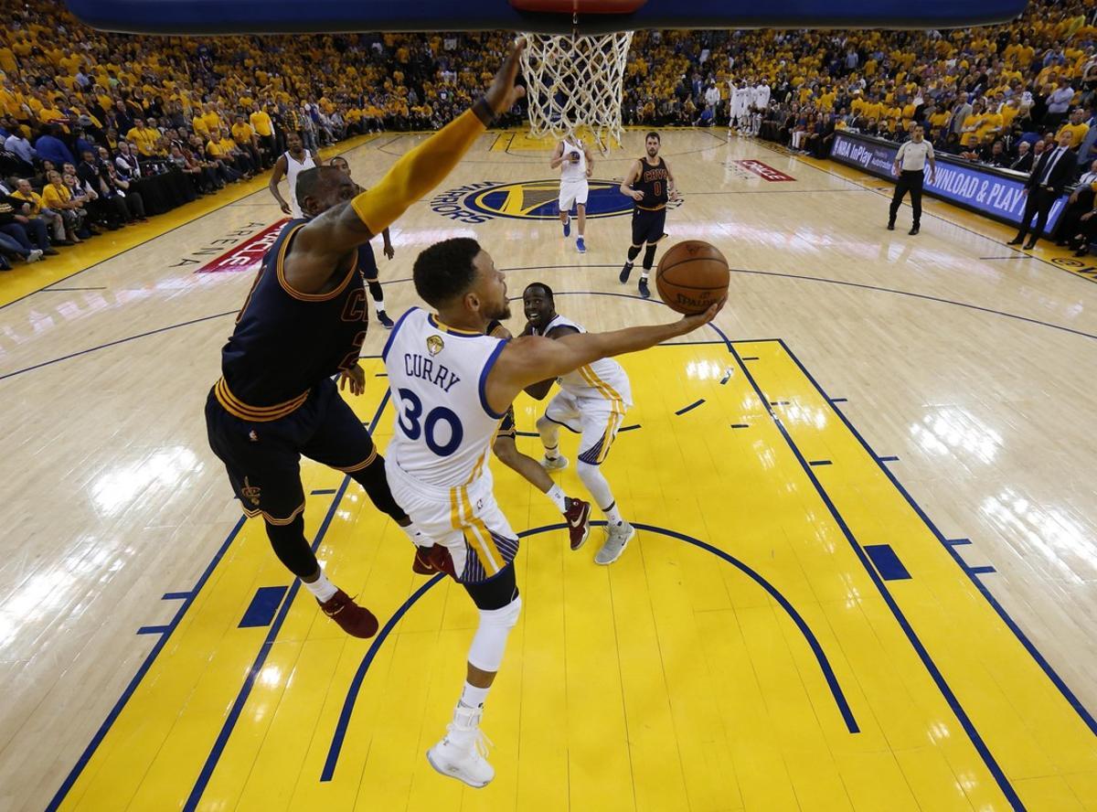 MON130. OAKLAND (EE.UU.), 01/06/2017.- Stephen Curry (c) de Golden State Warriors disputa el balón con LeBron James (i) de Cleveland Cavaliers hoy, jueves 1 de junio de 2017, durante el primer juego de la final de la NBA entre Cleveland Cavaliers y Golden State Warriors, que se disputa en el Oracle Arena, en Oakland, California (Estados Unidos). EFE/MARCIO JOSE SANCHEZ / POOL