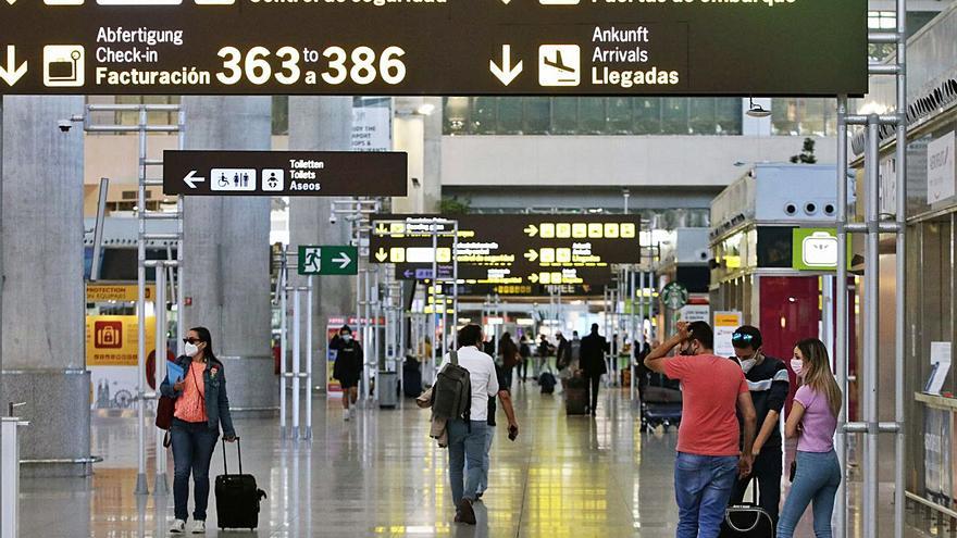 Varios turistas hacen cola en una de las puertas de embarque.