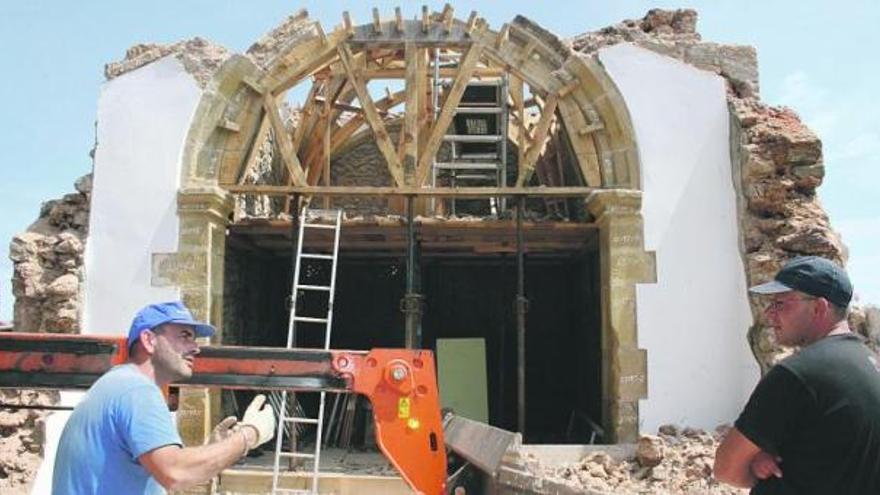 Dos trabajadores del desmontaje de San Antonio, Valdés y Toimil, delante del arco principal del templo, ayer.