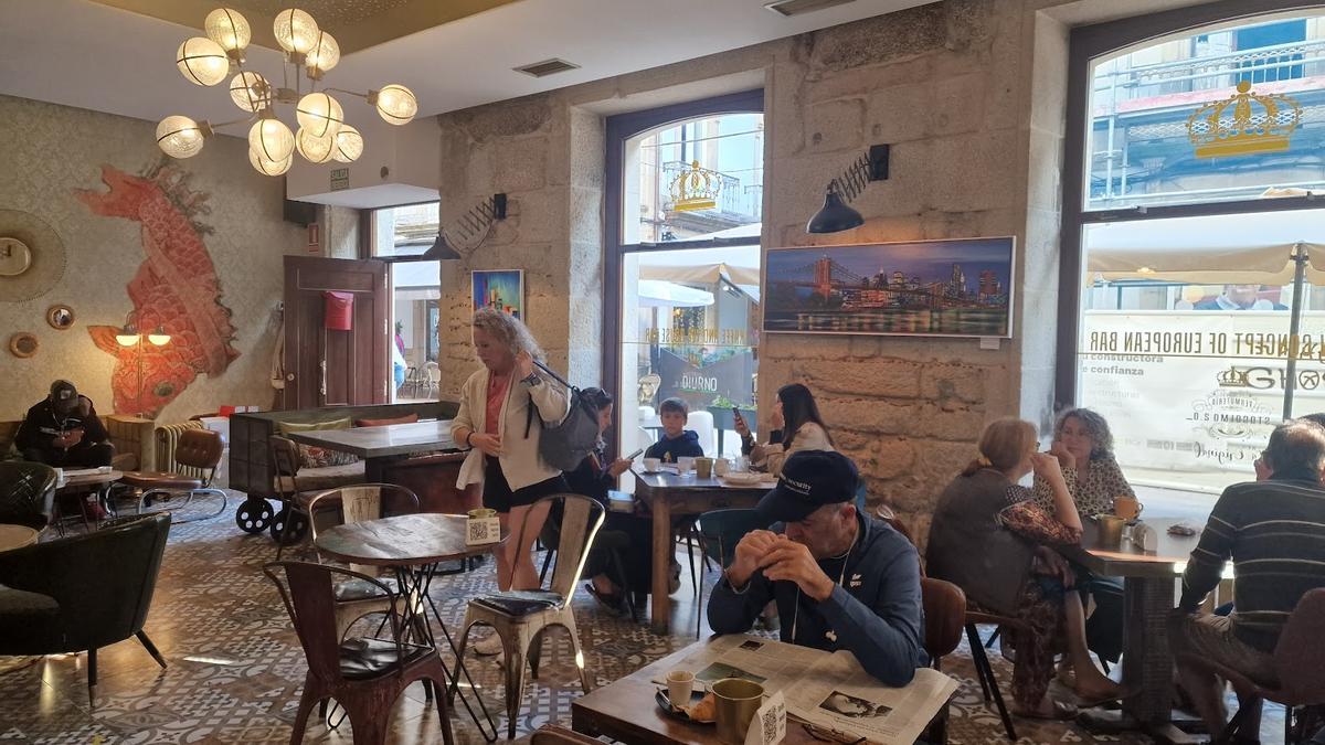 El interior de la cafetería, con los cuadros colgados de sus paredes.