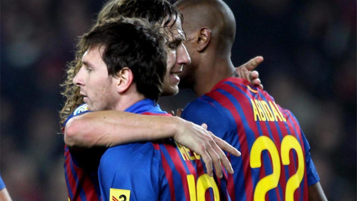 Messi, Puyol y Abidal se abrazan en un partido de la temporada 2011-12