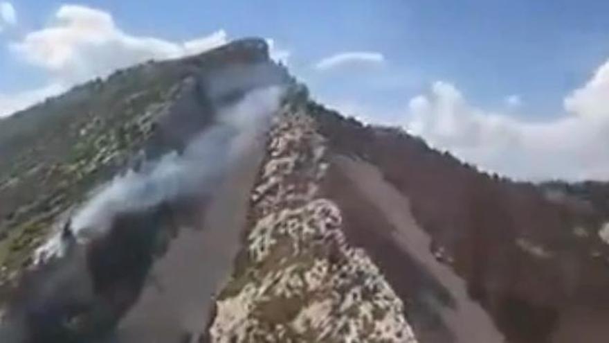 Els Bombers treballen en l'extinció d'un foc a una zona de dificil accés a Gisclareny