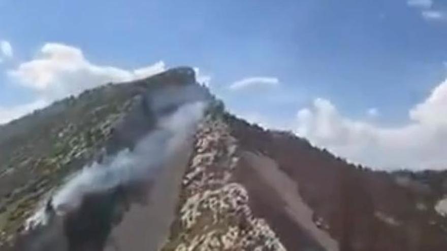 Els Bombers treballen en l'extinció d'un foc a una zona de dificil accés a Gisclareny