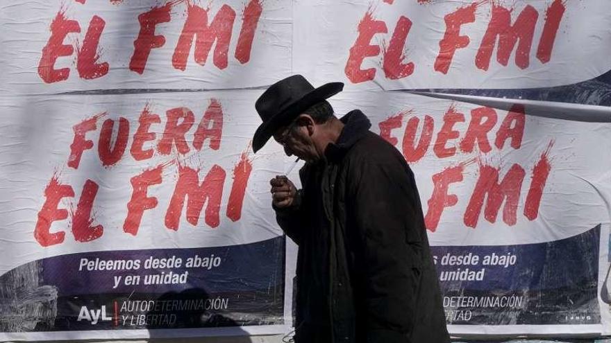 Un transeúnte, frente a carteles contra el FMI pegados en una calle de Buenos Aires. // Eitan Abramovich
