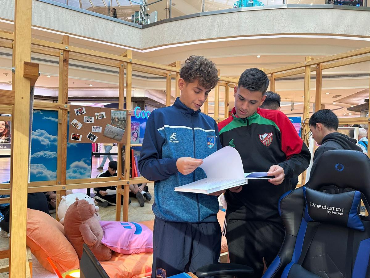 Varios jóvenes visitan la habitación de adolescente que se ha montado en la campaña 'Preguntar Cura'