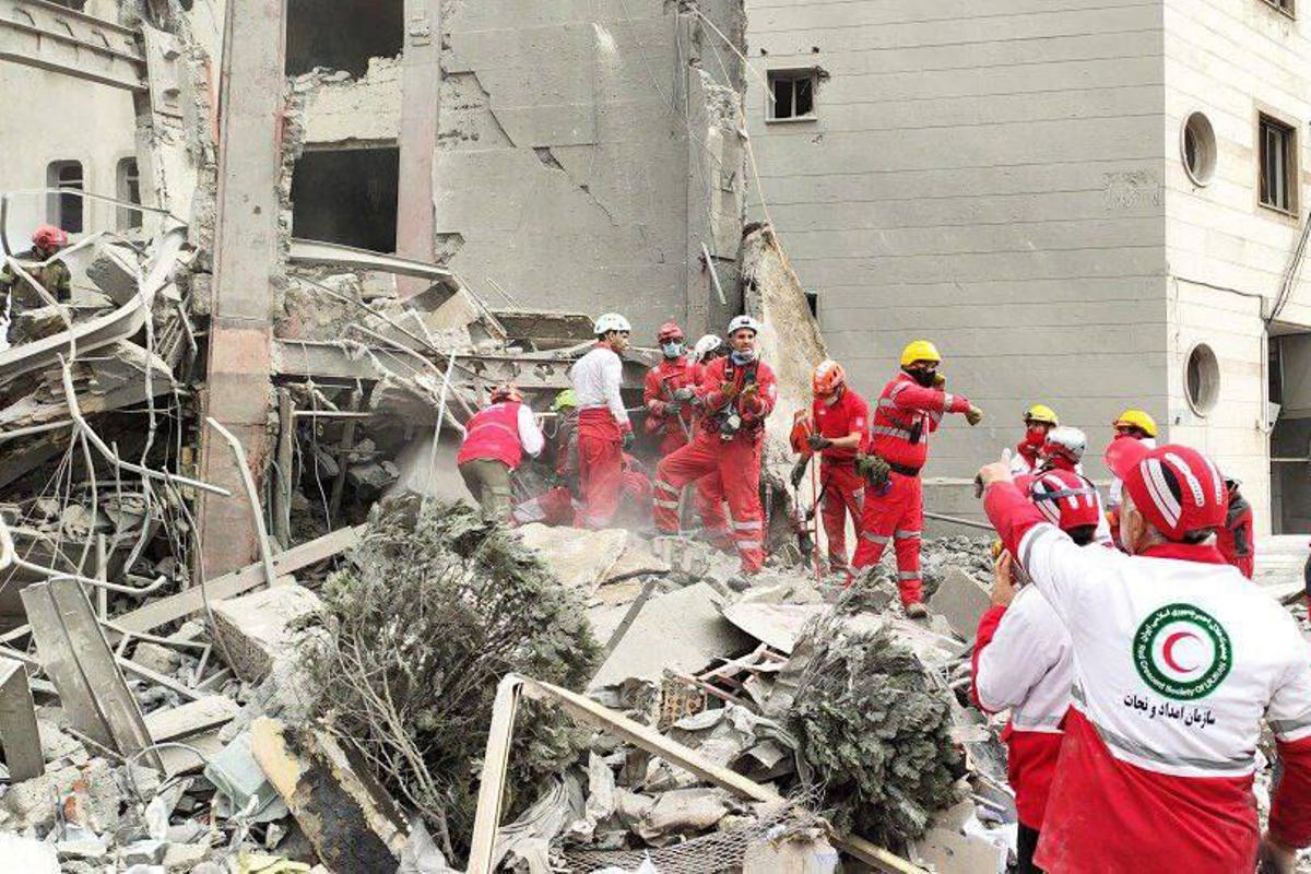 Equipos de rescate de la Sociedad de la Media Luna Roja Iraní (IRCS) trabajan en el lugar donde se encuentra un edificio dañado por un ataque aéreo en Teherán.