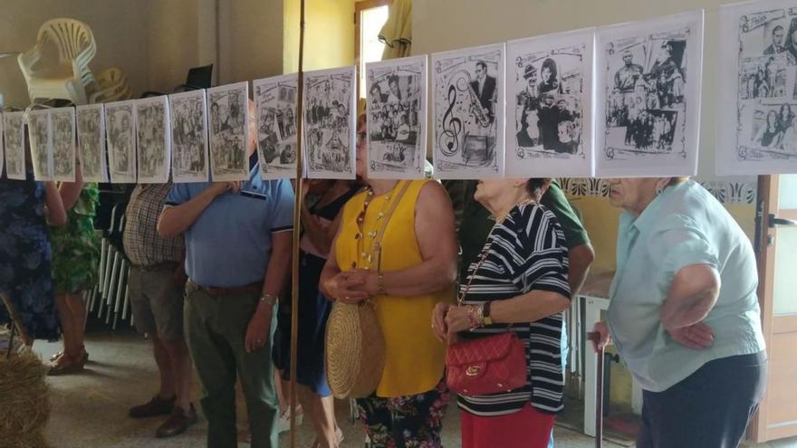 Vecinos de Villaescusa visitan la exposición en el salón de baile.