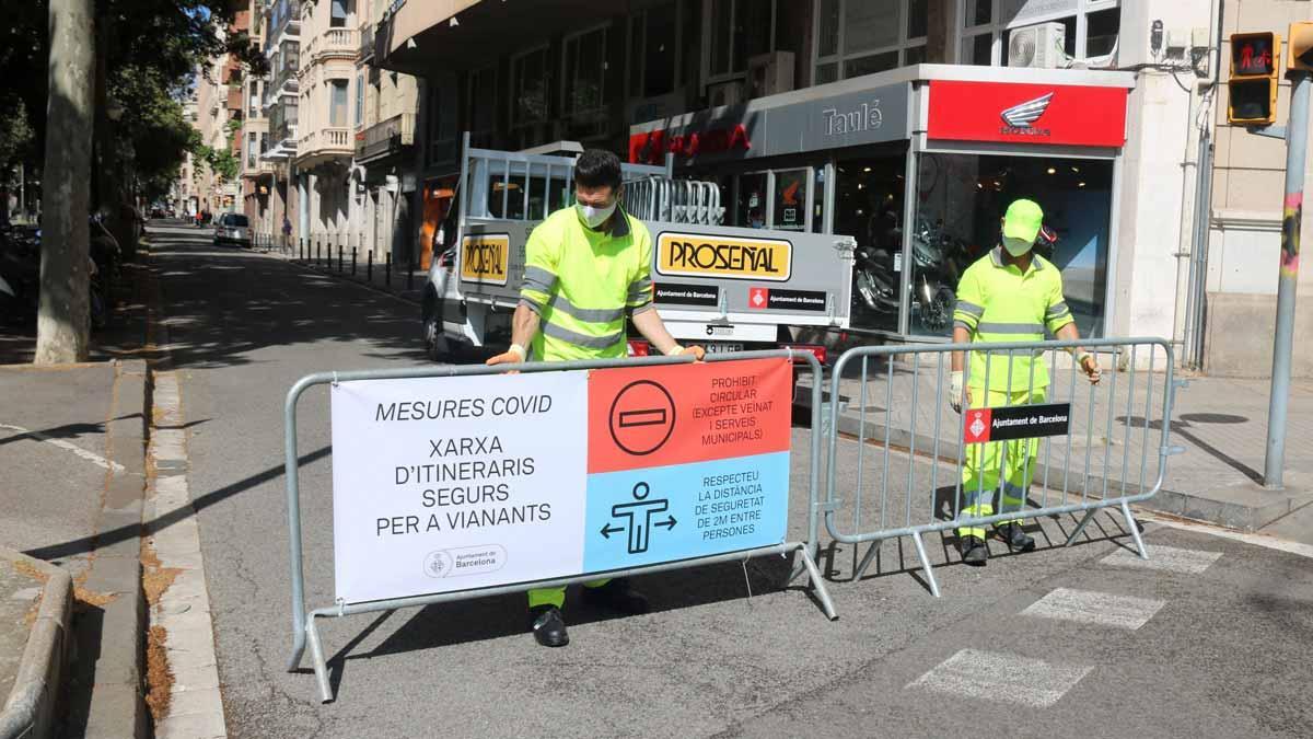 Colocación de vallas para cortar el tráfico en el lateral de la Diagonal con el paseo de Sant Joan, en Barcelona