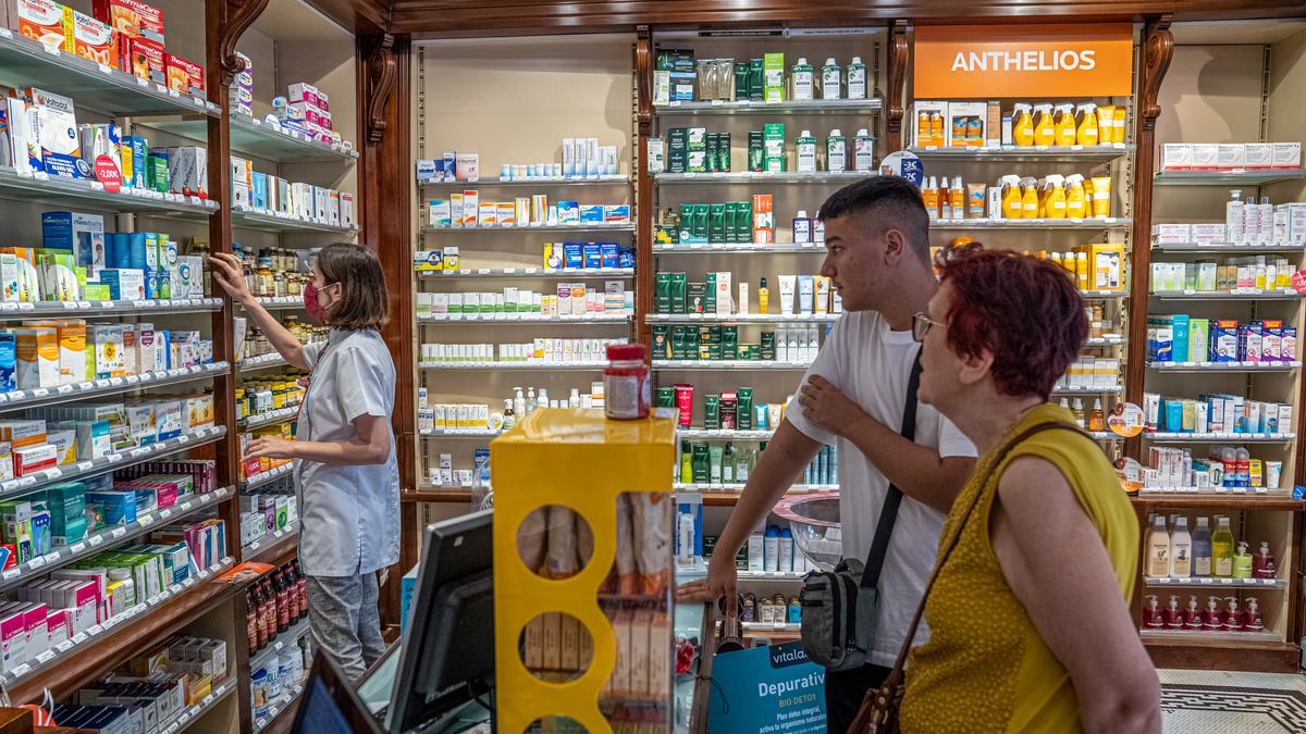 Dos clientes de una farmacia, sin mascarilla, este martes, antes de que entre en vigor oficialmente la retirada de los tapabocas.