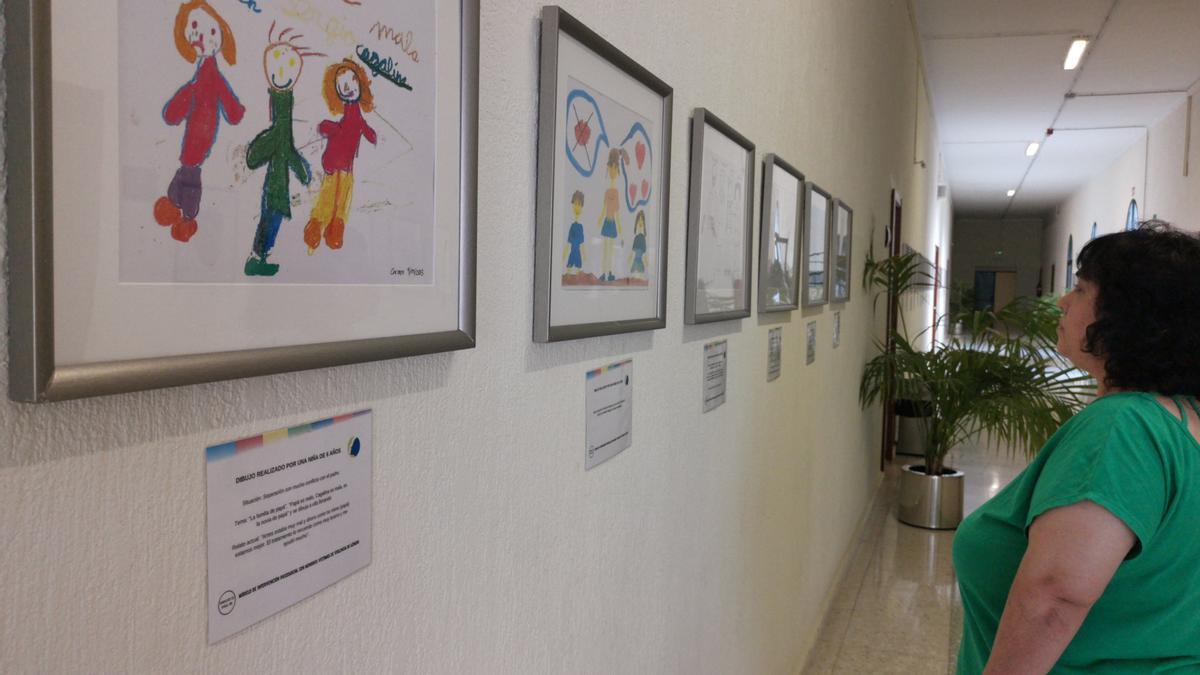 Una persona visita la exposición con los dibujos realizados por niños que han sufrido la violencia machista en sus hogares.