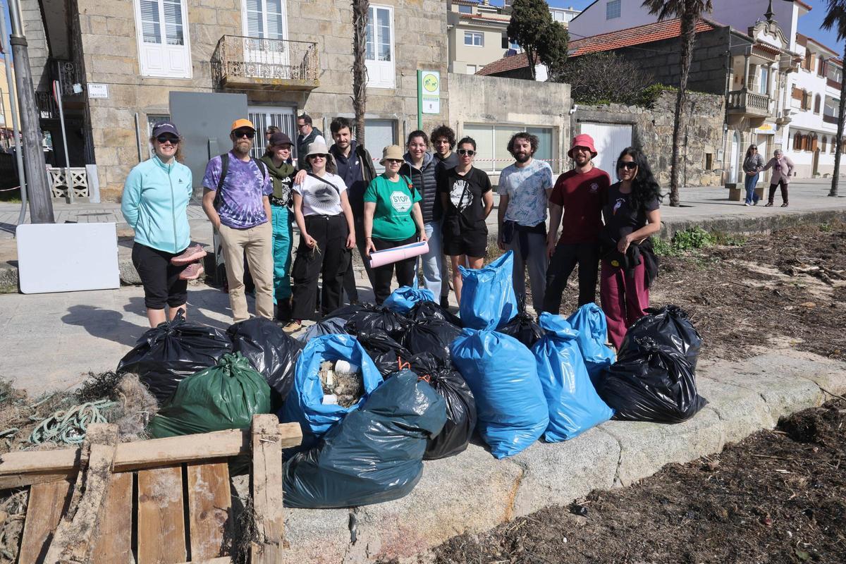 Voluntarios tras la recogida de residuos en parte de la playa de Panxón