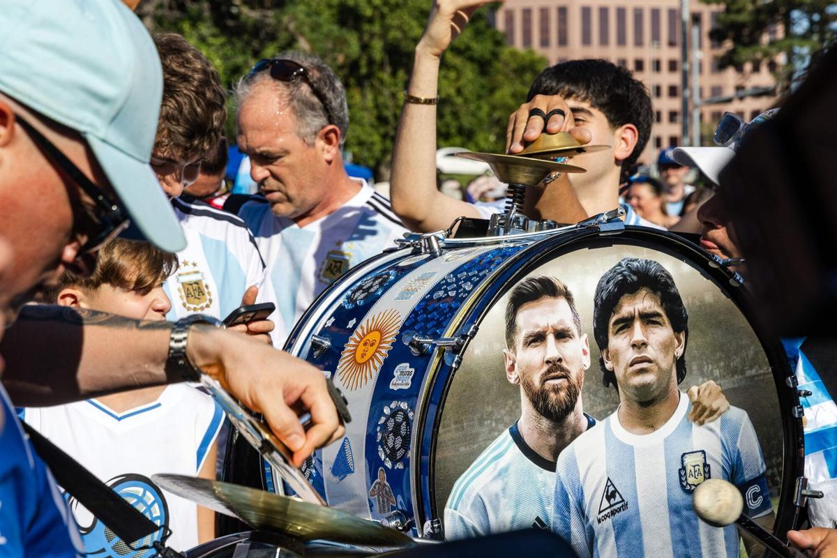 Argentina's fans play a drum decorated with images of current team captain Lionel Messi and late Argentine legend Diego Maradona while gathering at Mill Creek Park on the eve of the World Cup quarterfinal match between Argentina and Switzerland, in Kansas City, Missouri, on July 10, 2026. (Photo by Austin Johnson / AFP)