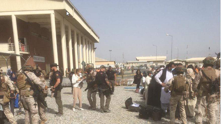 Policías y militares españoles reciben refugiados en el aeropuerto de Kabul, en una imagen difundida este sábado por el Ministerio de Defensa.