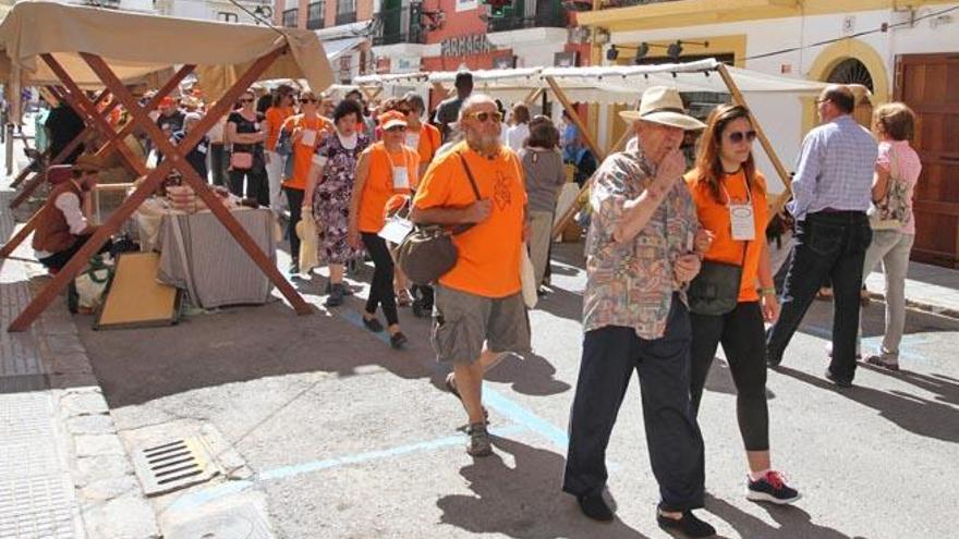 Voluntarios y mayores pasean entre los puestos de la Feria Ibiza Medieval.