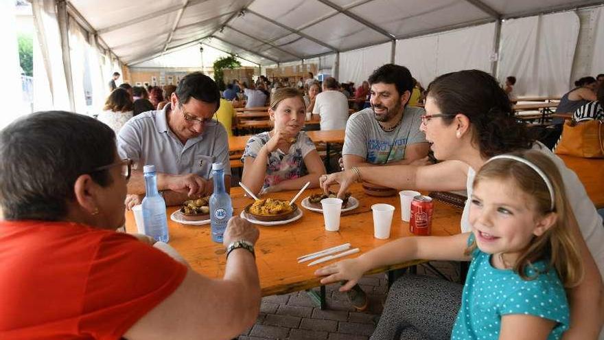 Una familia degusta la almeja en la carpa instalada en Campelo.  // Gustavo Santos