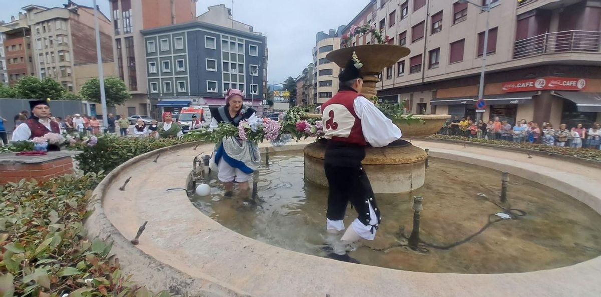 Integrantes de Ruxidera, enramando la fuente del Vasco. | D. M.