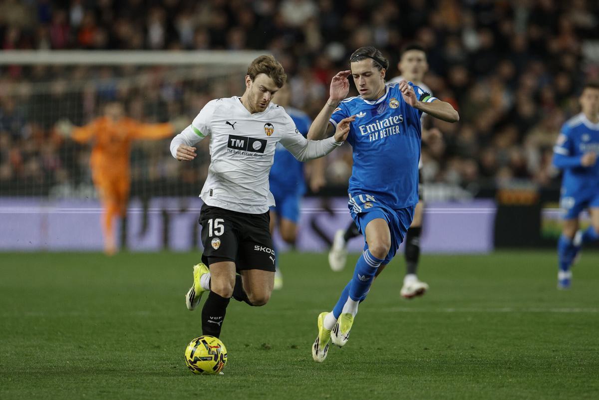 VALENCIA, 08/02/2026.- El delantero del Valencia Lucas Beltrán (i) con el balón ante el defensa del Real Madrid Álvaro Carreras durante el partido de la jornada 23 de Liga que el conjunto blanco disputa ante el Valencia, este domingo en el estadio de Mestalla. EFE/Kai Forsterling