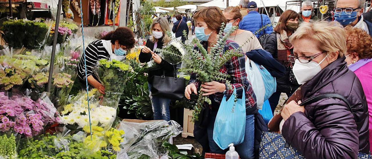 Visitantes agolpados junto a un puesto de flores en la feria de Valença.   | // MARTA G. BREA