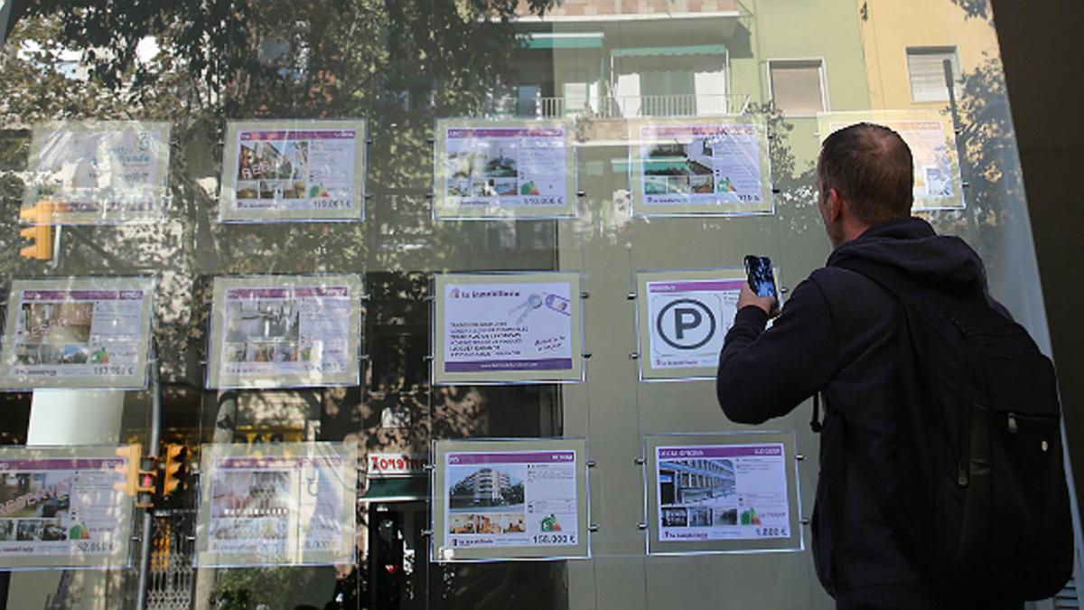 Hombre busca un piso de alquiler en una inmobiliaria de Barcelona.