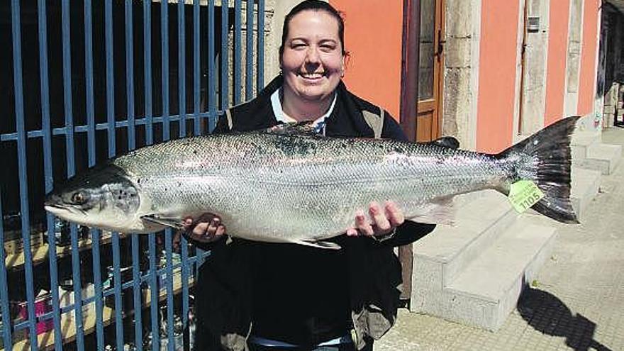 La ribereña del Sella Silvia García López exhibe su enorme salmón de casi 12 kilos.