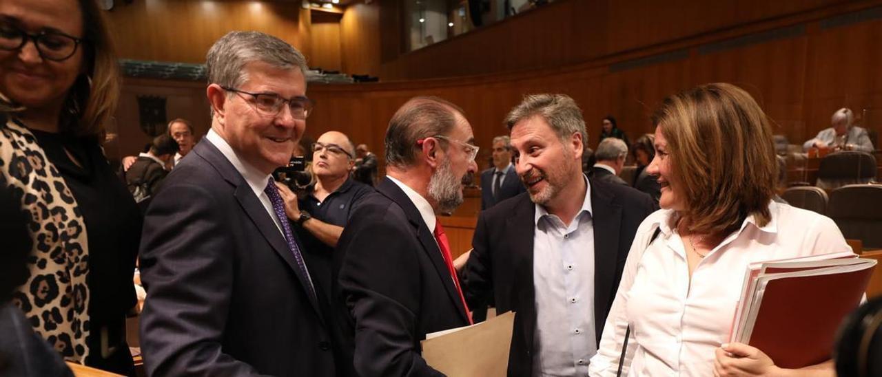 El presidente de Aragón, Javier Lambán, saluda a José Luis Soro, consejero de Vertebración del Territorio, en un momento de la segunda jornada del debate del estado de la comunidad