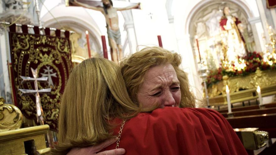 Dos cofrades del Cristo de la Salud lloran al suspenderse la procesión en Murcia.