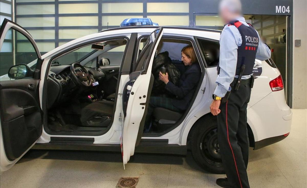 Carme Forcadell sentada en la parte de atrás de un coche de los Mossos, el día de su traslado a Madrid.