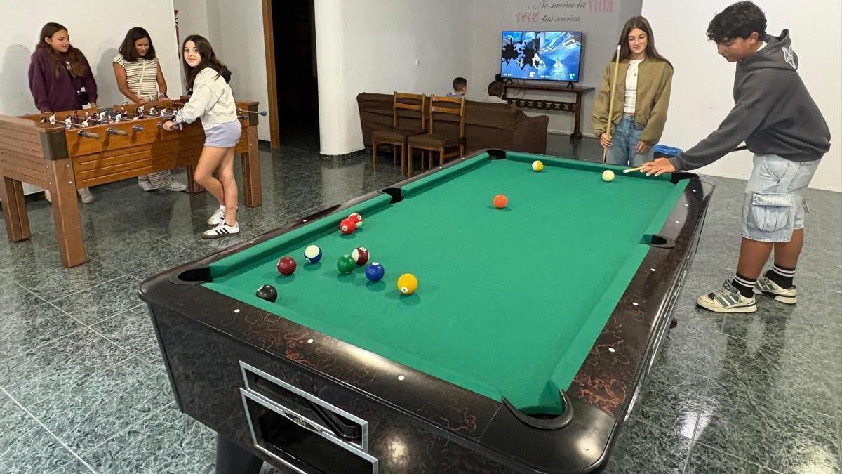 Varios jóvenes en los distintos juegos de la sala principal del Centro de Ocio.