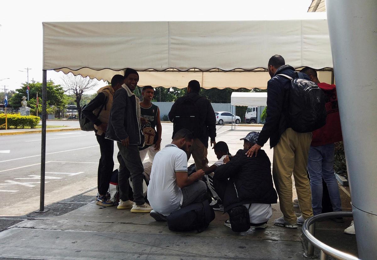 Migrantes de la India se reúnen frente al Aeropuerto Internacional de Managua después de llegar a Nicaragua para continuar su viaje a los Estados Unidos.