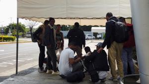 Migrantes de la India se reúnen frente al Aeropuerto Internacional de Managua después de llegar a Nicaragua para continuar su viaje a los Estados Unidos.