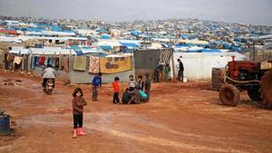 Los niños se reúnen fuera de sus refugios improvisados después de una lluvia torrencial que afectó a un campamento para personas desplazadas cerca de la ciudad de Atme, cerca de la frontera con Turquía, en la provincia de Idlib, al norte de Siria.