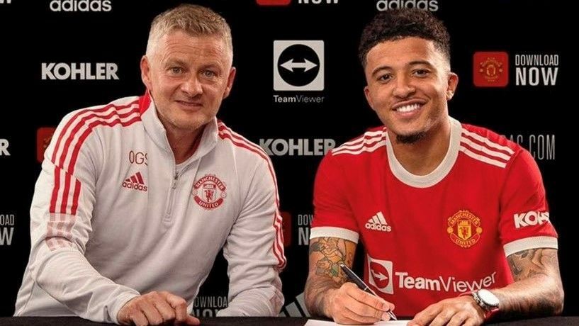 Sancho firma su contrato con el United junto a su nuevo técnico, Solskjaer.