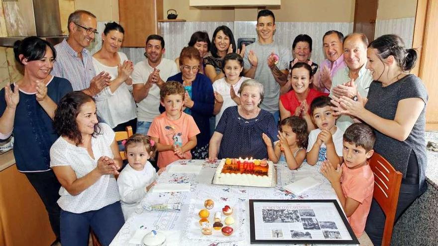 Zoraida y su familia, ante la tarta que compartieron en la fiesta de su centenario y el reportaje de FARO enmarcado que recibió como regalo por parte de una vecina. // Marta G. Brea