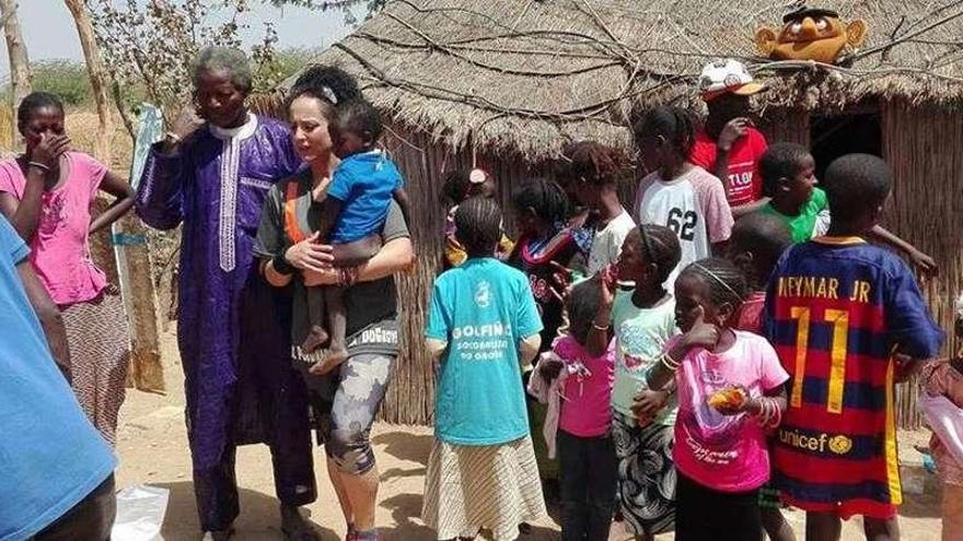 Nati Villanueva, con un niño en brazos, a su llegada al poblado. // FdV