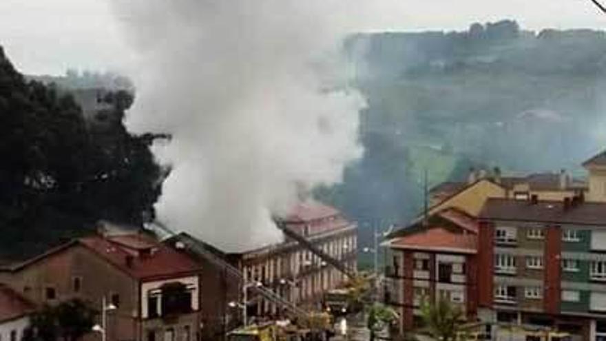 Efectivos de bomberos, sofocando el incendio, ayer en Perán.